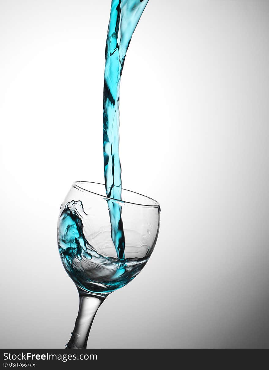 Dark blue water flows in a wine-glass. In a glass from glass a wave. Dark blue water flows in a wine-glass. In a glass from glass a wave