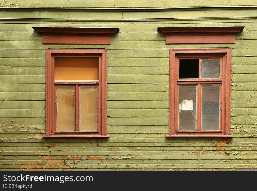 Old broken window on a green wooden wall