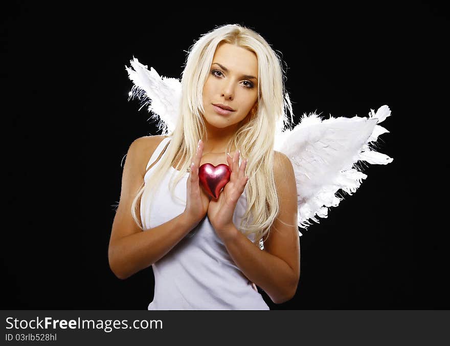 Portrait of a beautiful angel girl holding a heart