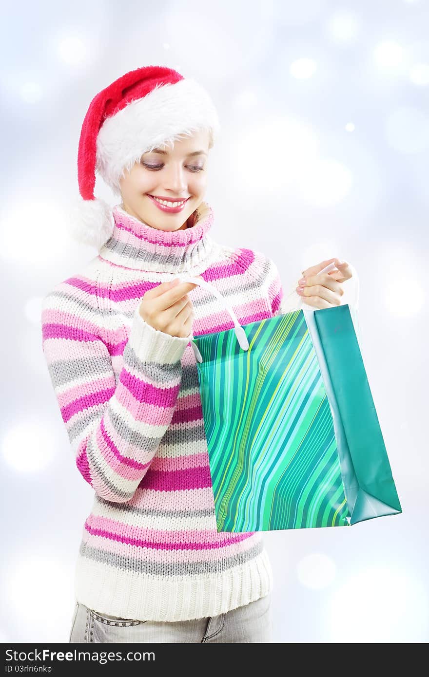 Santa girl holding shopping bag on a light background