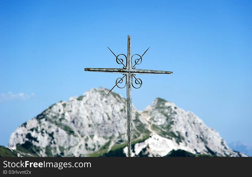 Cross of iron in front of blue sky and mighty hills. Cross of iron in front of blue sky and mighty hills