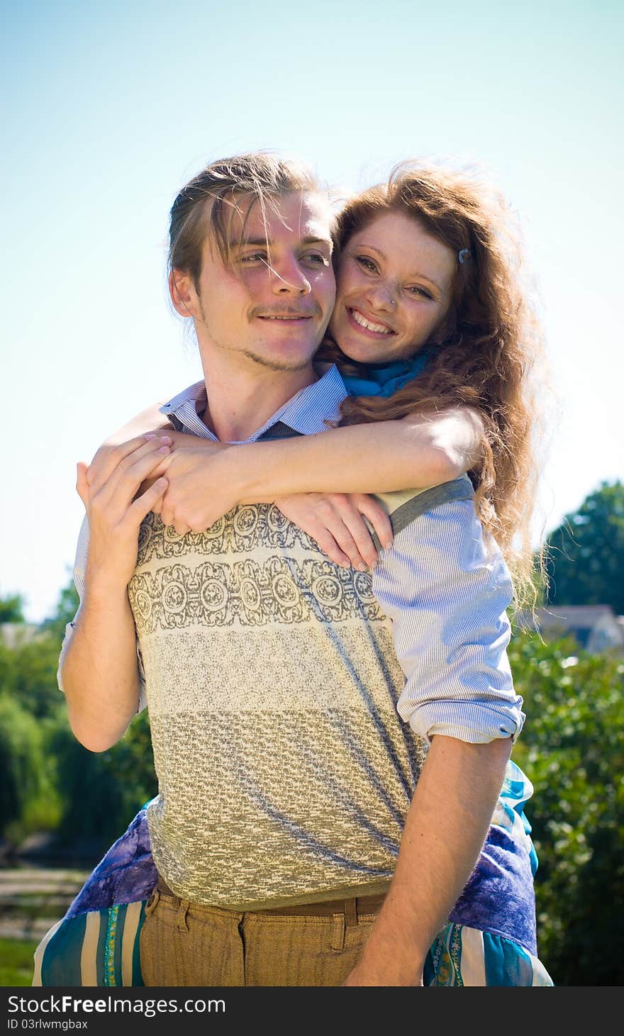 Happy couple hugging on blue sky background