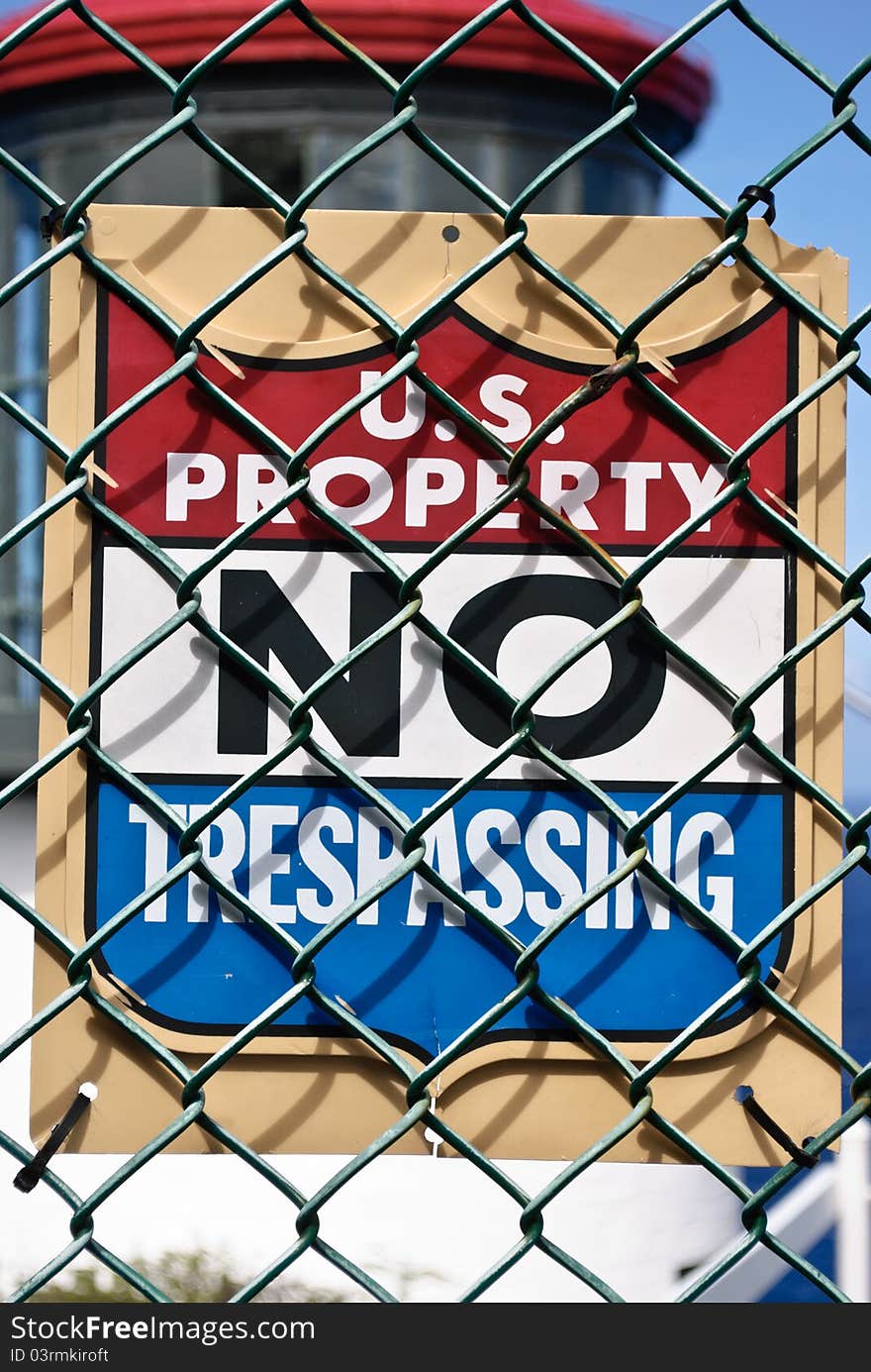 U.S. Property NO TRESPASSING sign posted on chain link fence in front of Makapu'u Lighthouse on Oahu, Hawaii.