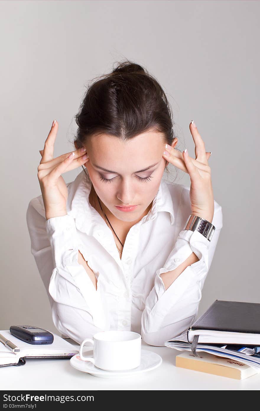 The tired woman is sitting on her workplaces. The tired woman is sitting on her workplaces