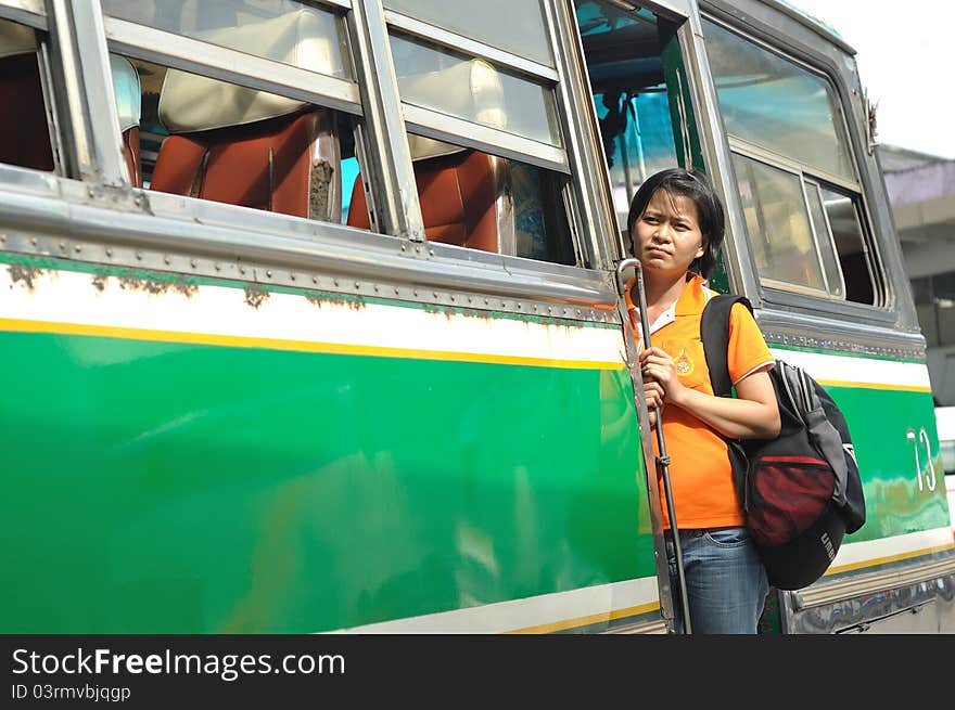 A passenger lady stand on the bus door