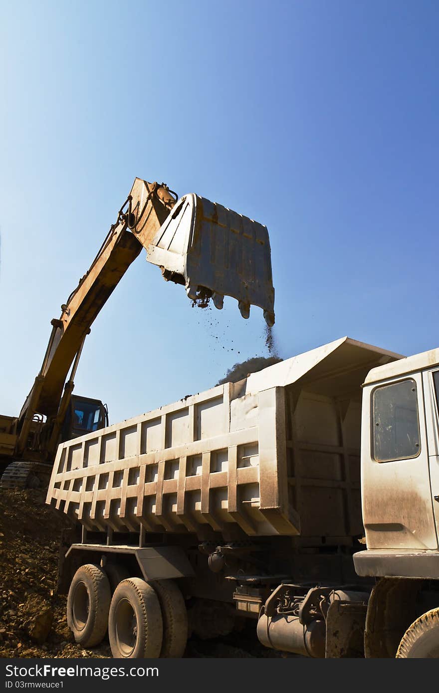 Excavator loader and truck during Earth moving works outdoors  at the quarry