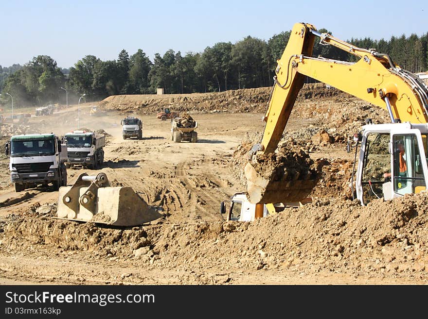 Excavator on a construction site of movement of ground and rock. Excavator on a construction site of movement of ground and rock.