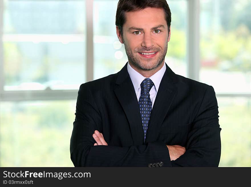 Business man standing in front of a window