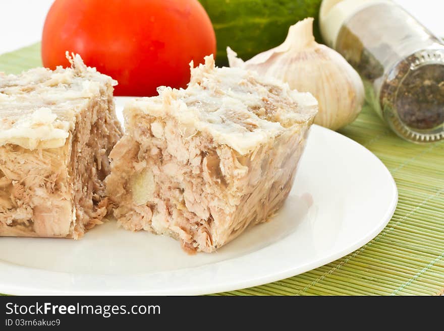 Jellied meat on a white plate against the vegetables