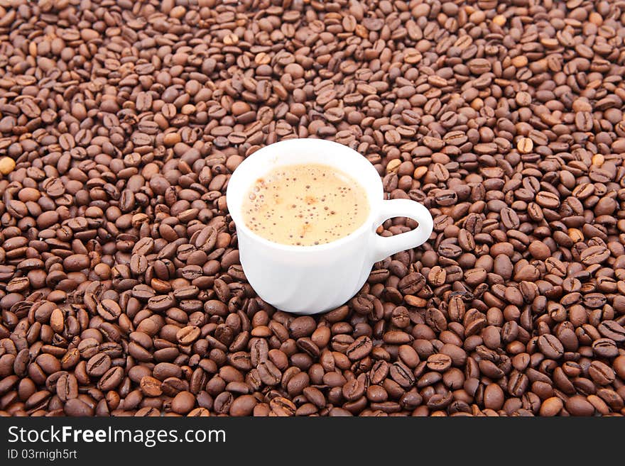 Cup of fresh coffee against coffee grains