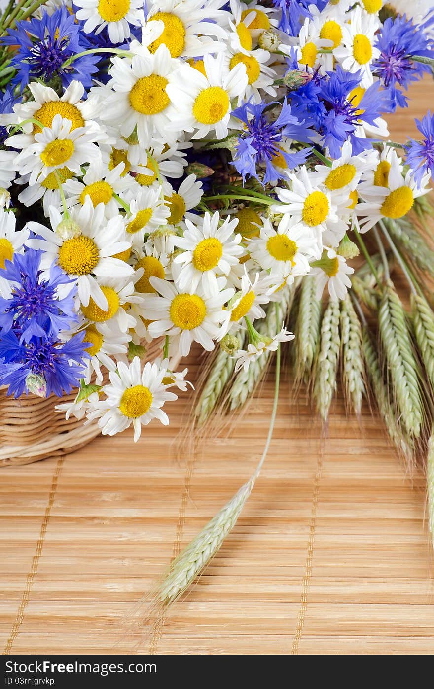 Beautiful flowers in a basket on bamboo background