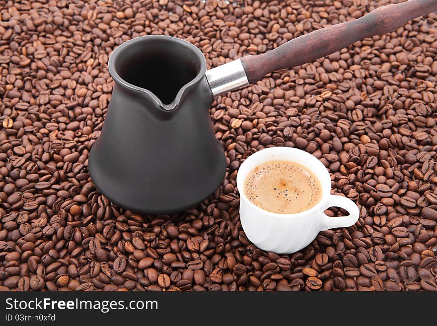 Cup of fresh coffee against coffee grains. Cup of fresh coffee against coffee grains