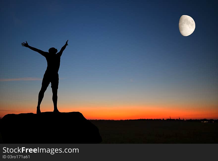 Man on top of the mountain reaches for the moon