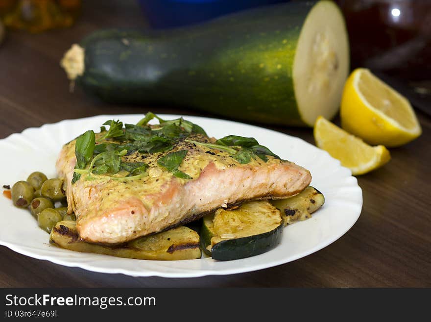 Tasty salmon filet on a white plate, with grilled vegetables. Tasty salmon filet on a white plate, with grilled vegetables