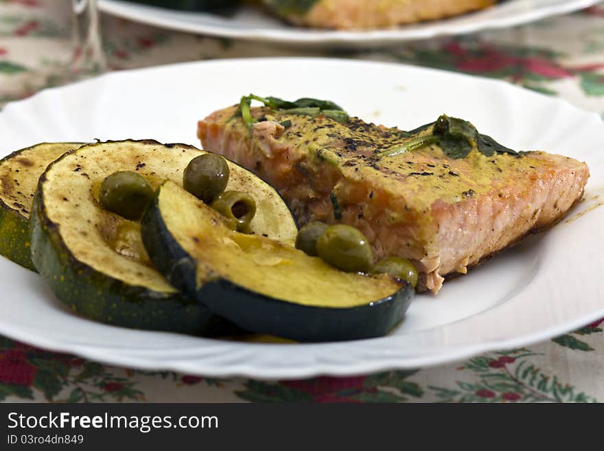 Tasty salmon filet on a white plate, with grilled vegetables. Tasty salmon filet on a white plate, with grilled vegetables