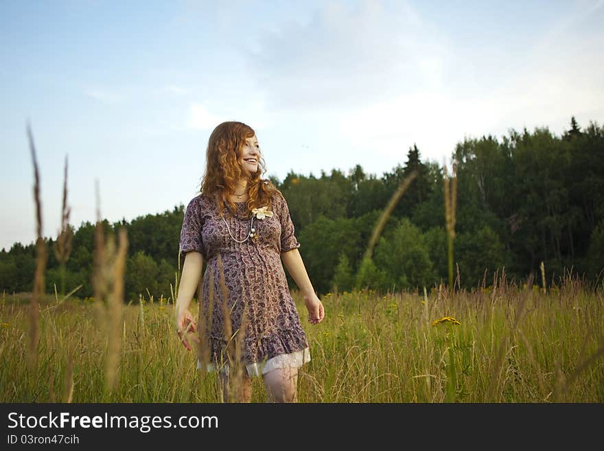 Beautiful pregnant girl on the field