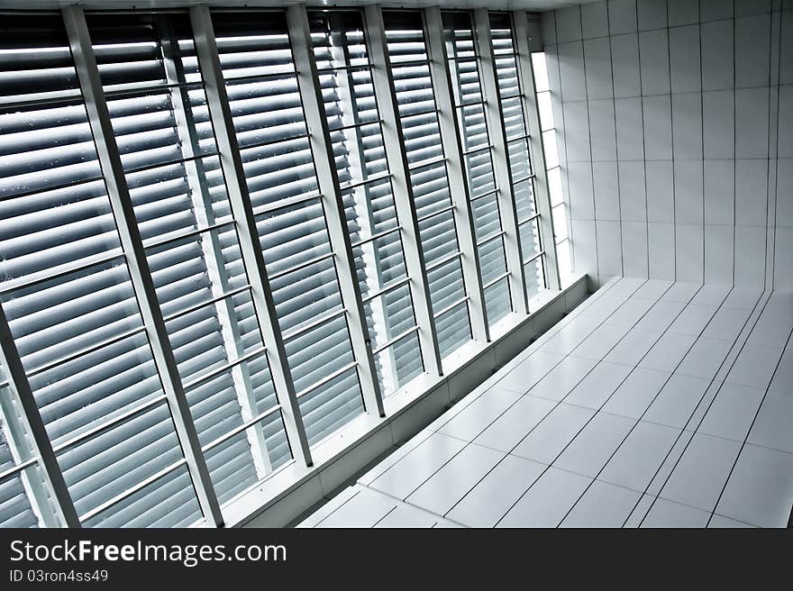 Contrast window panels with blinds beside tiled pathway