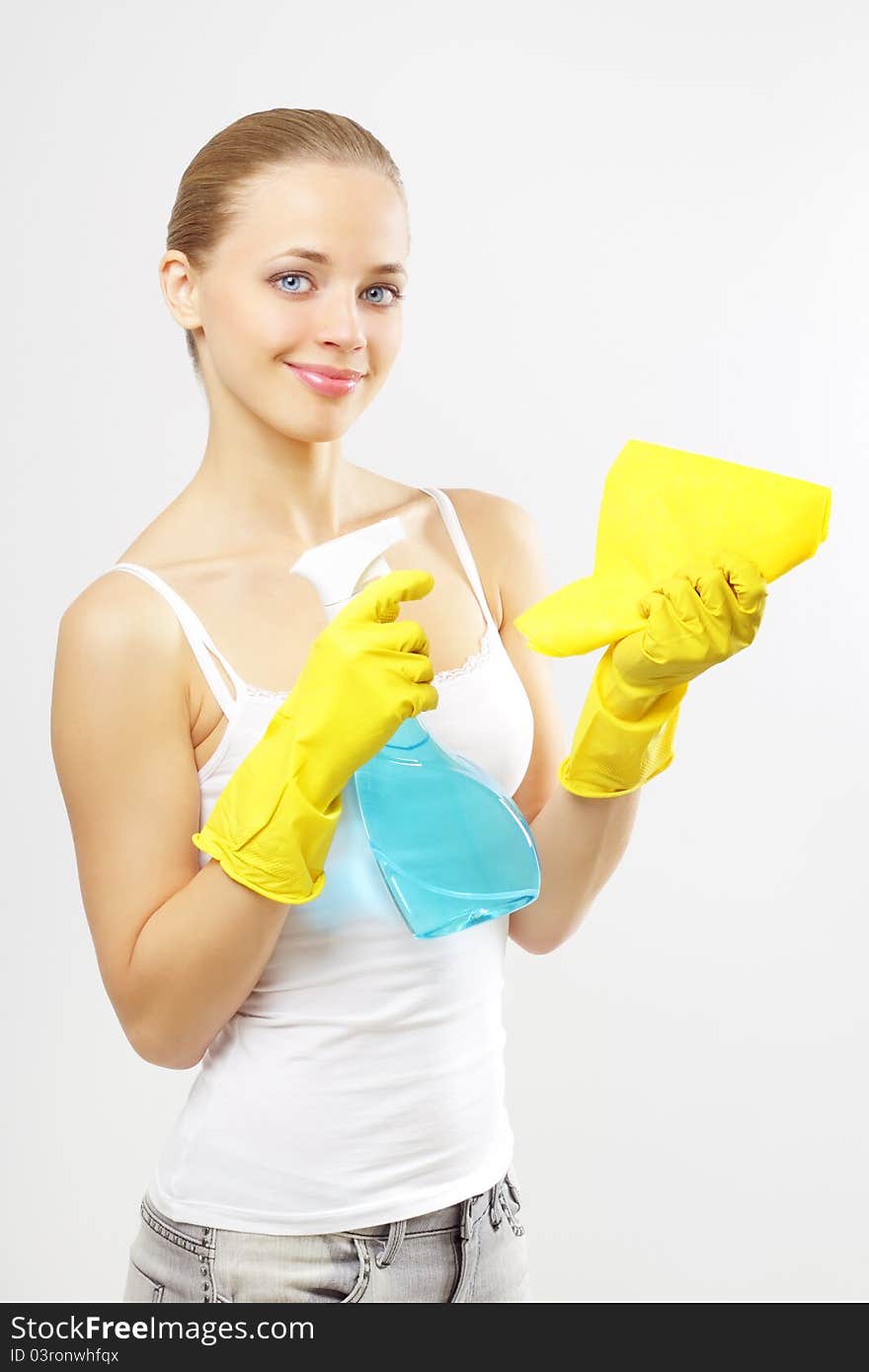 Woman holding glass cleaner and rag. gray background. Woman holding glass cleaner and rag. gray background