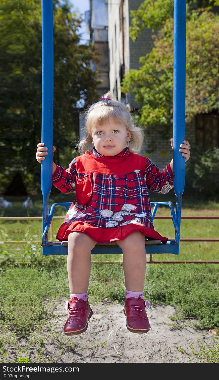 Adorable little girl having fun on a swing