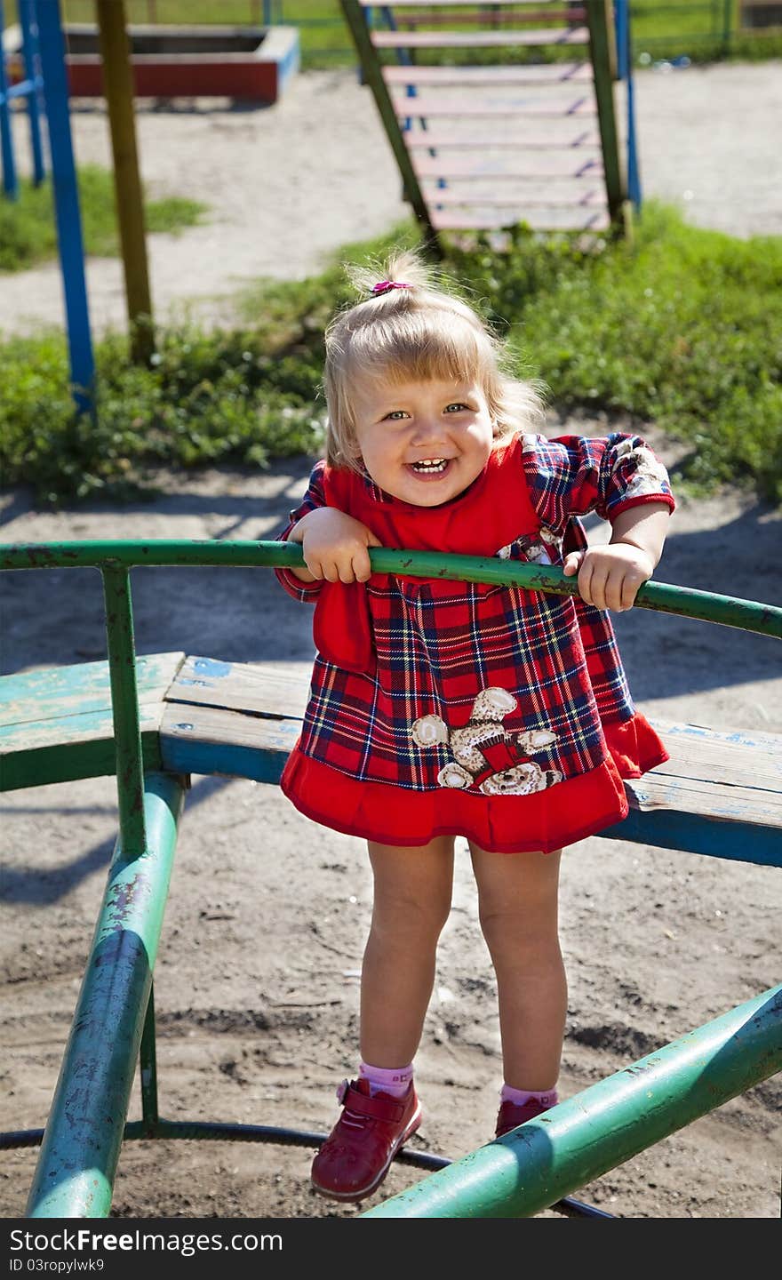 Adorable little girl playing in the playground in summer