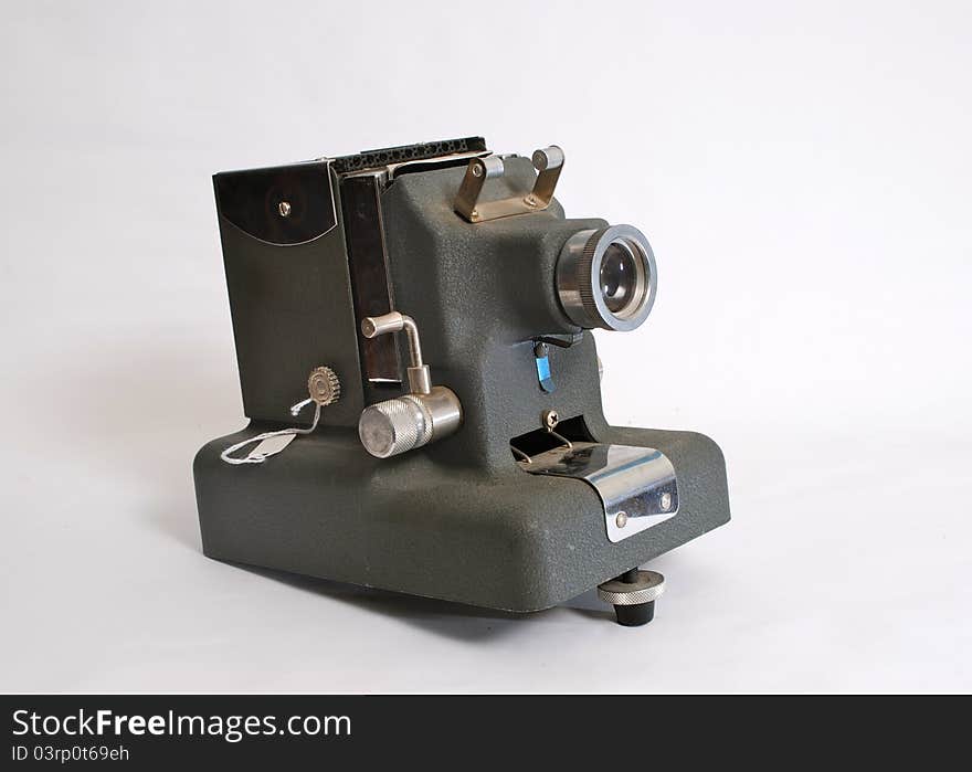 An Antique slide projector made of grey metal on an easily removable light grey background.