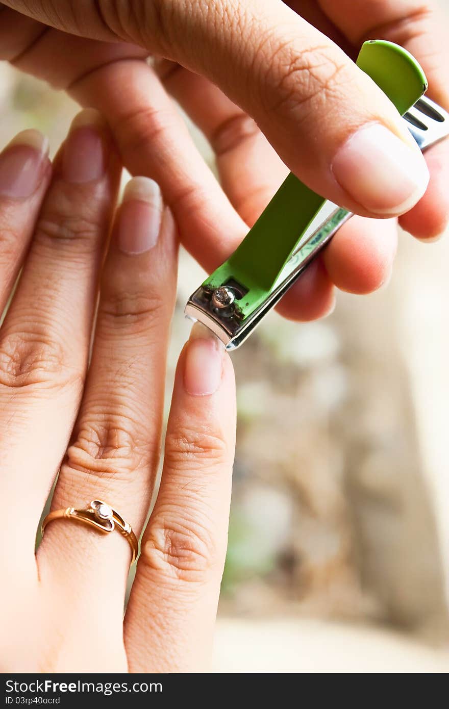 Girl cutting her nail by left hand. Girl cutting her nail by left hand