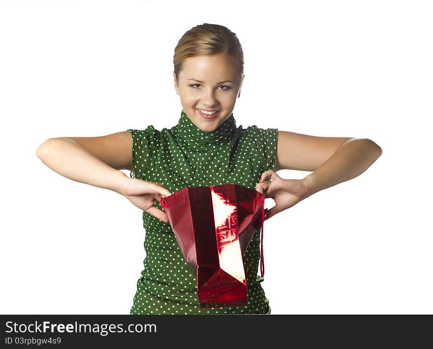 Surprised young girl is opening gift bag and crafty smiling isolated over white. Surprised young girl is opening gift bag and crafty smiling isolated over white