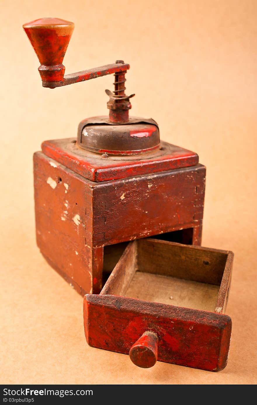 Old red coffee mill with open empty container