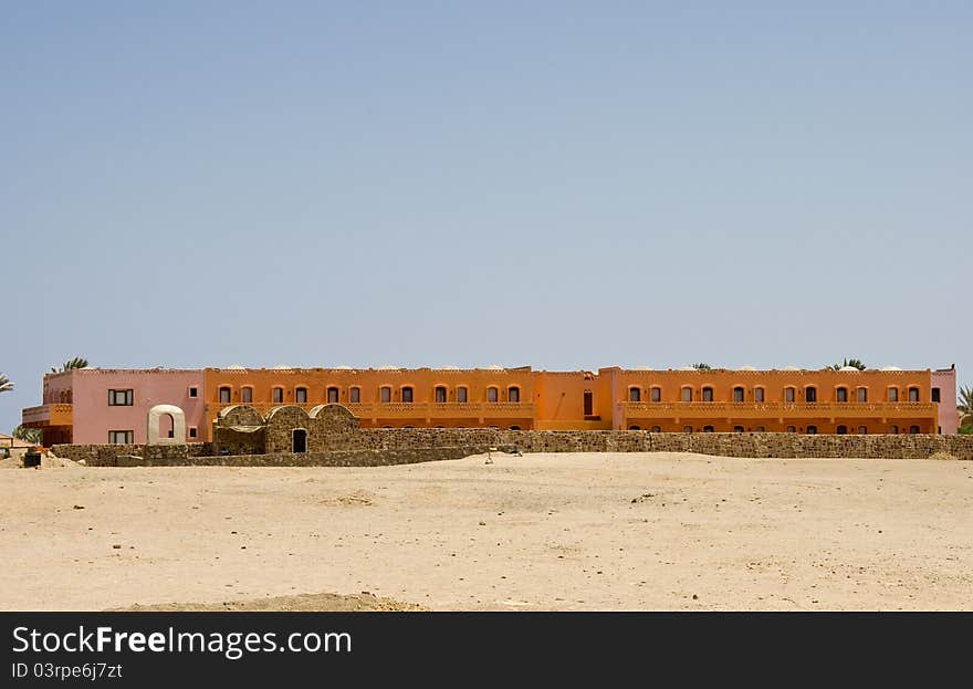 Nice orange hotel in Egypt with clear sky and wall. Summer vacation concept.