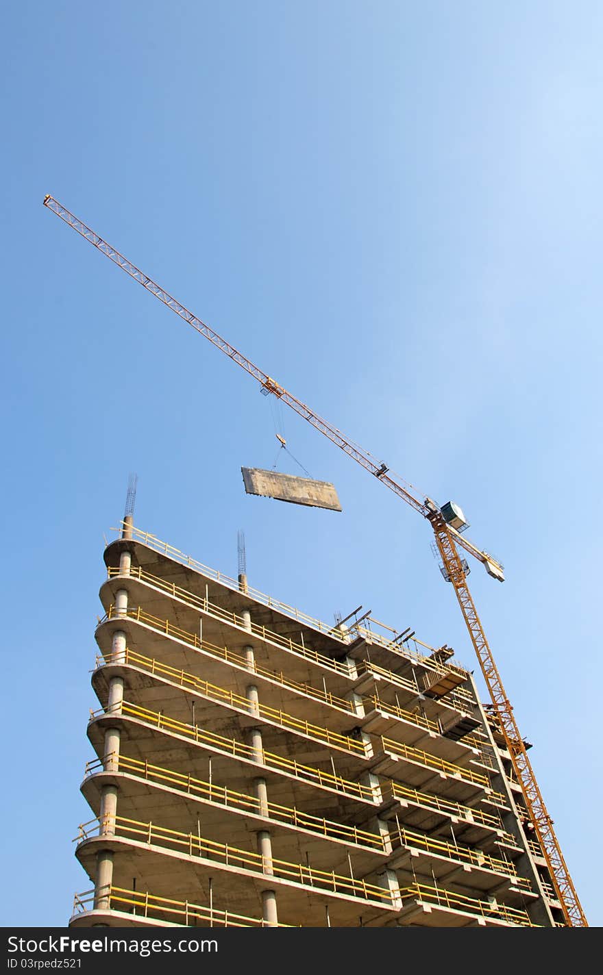 Crane and building construction site against blue sky. Crane and building construction site against blue sky