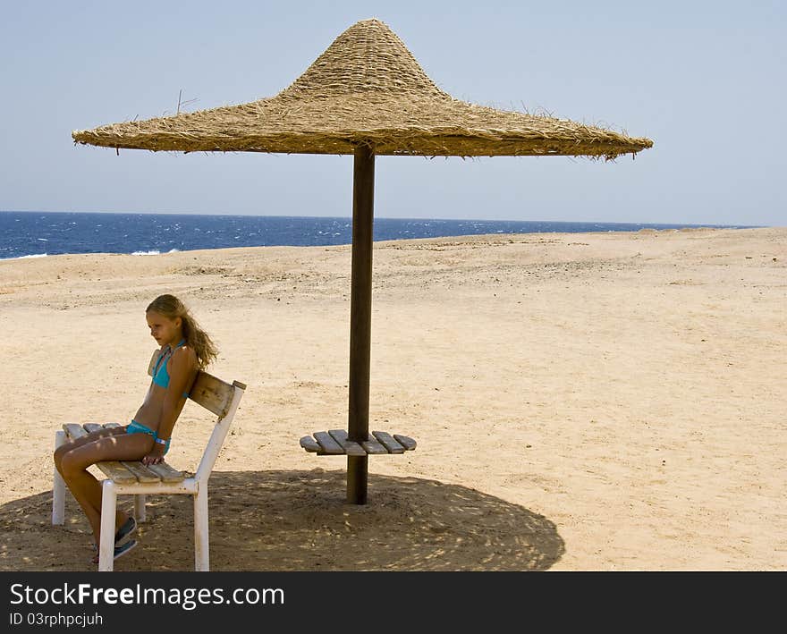 Blond girl sitting on the bench at the Red Sea Marsa Alam in Egypt