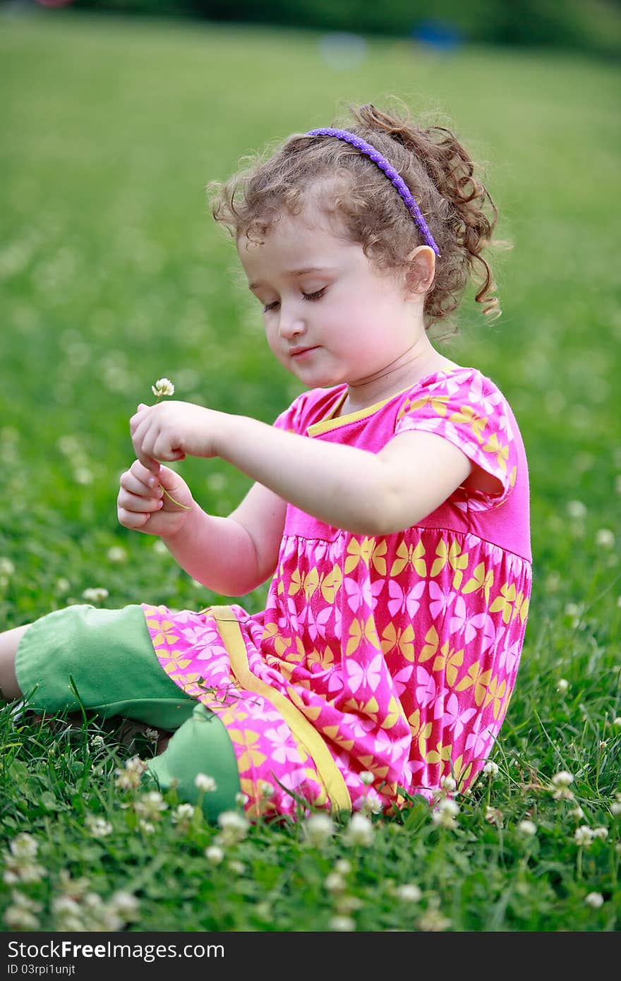 Little girl is picking flowers on field