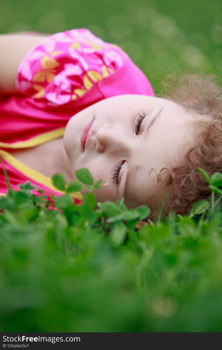 Little adorable girl lying on grass