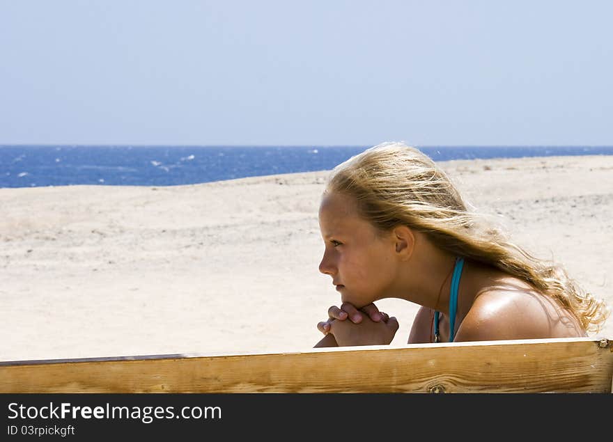 Blond girl sitting on the bench