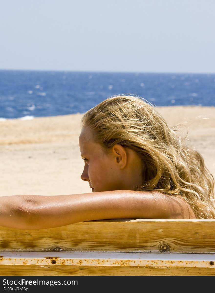 Blond girl sitting on the bench at the Red Sea Marsa Alam in Egypt