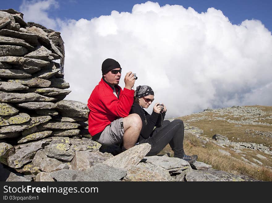 Hiker couple taking pictures up in the mountains