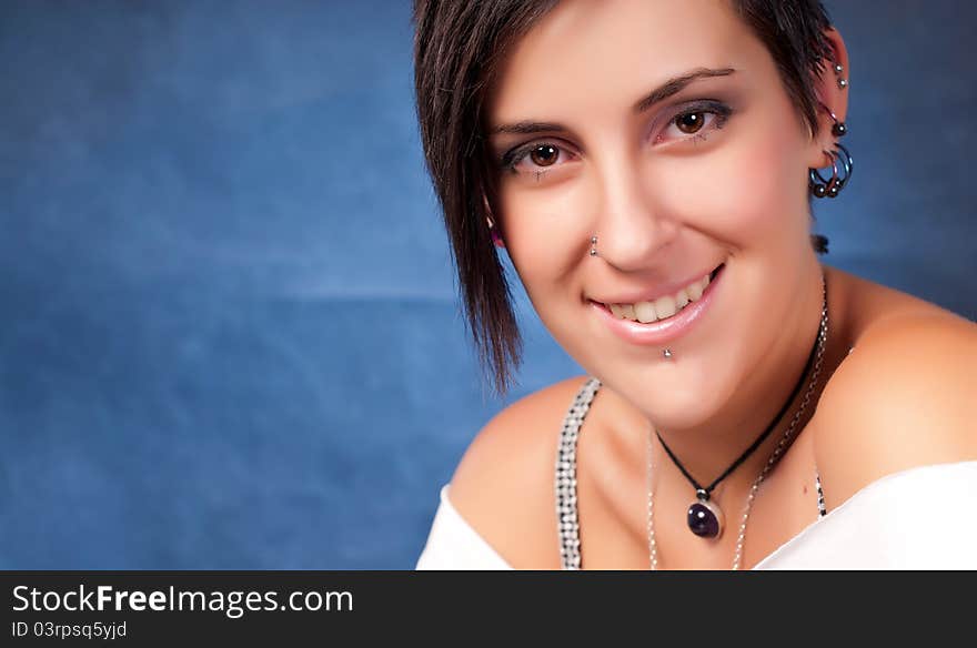 Happy brunette teenager girl with rock attitude on blue background. Happy brunette teenager girl with rock attitude on blue background