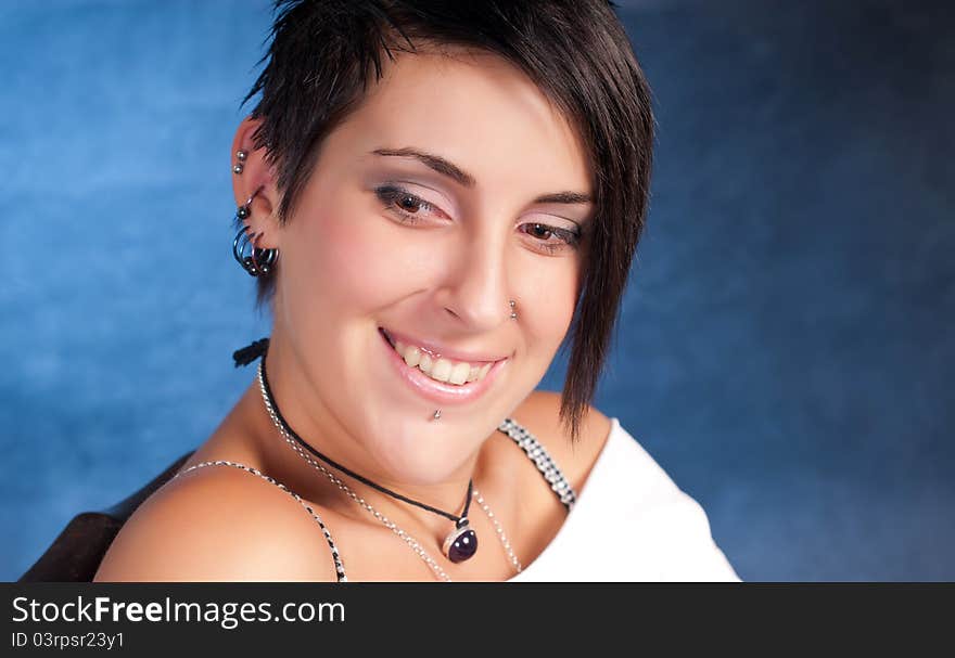 Happy brunette teenager girl with rock attitude on blue background. Happy brunette teenager girl with rock attitude on blue background