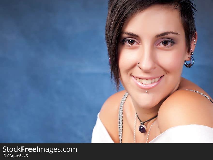 Happy brunette teenager girl with rock attitude on blue background. Happy brunette teenager girl with rock attitude on blue background