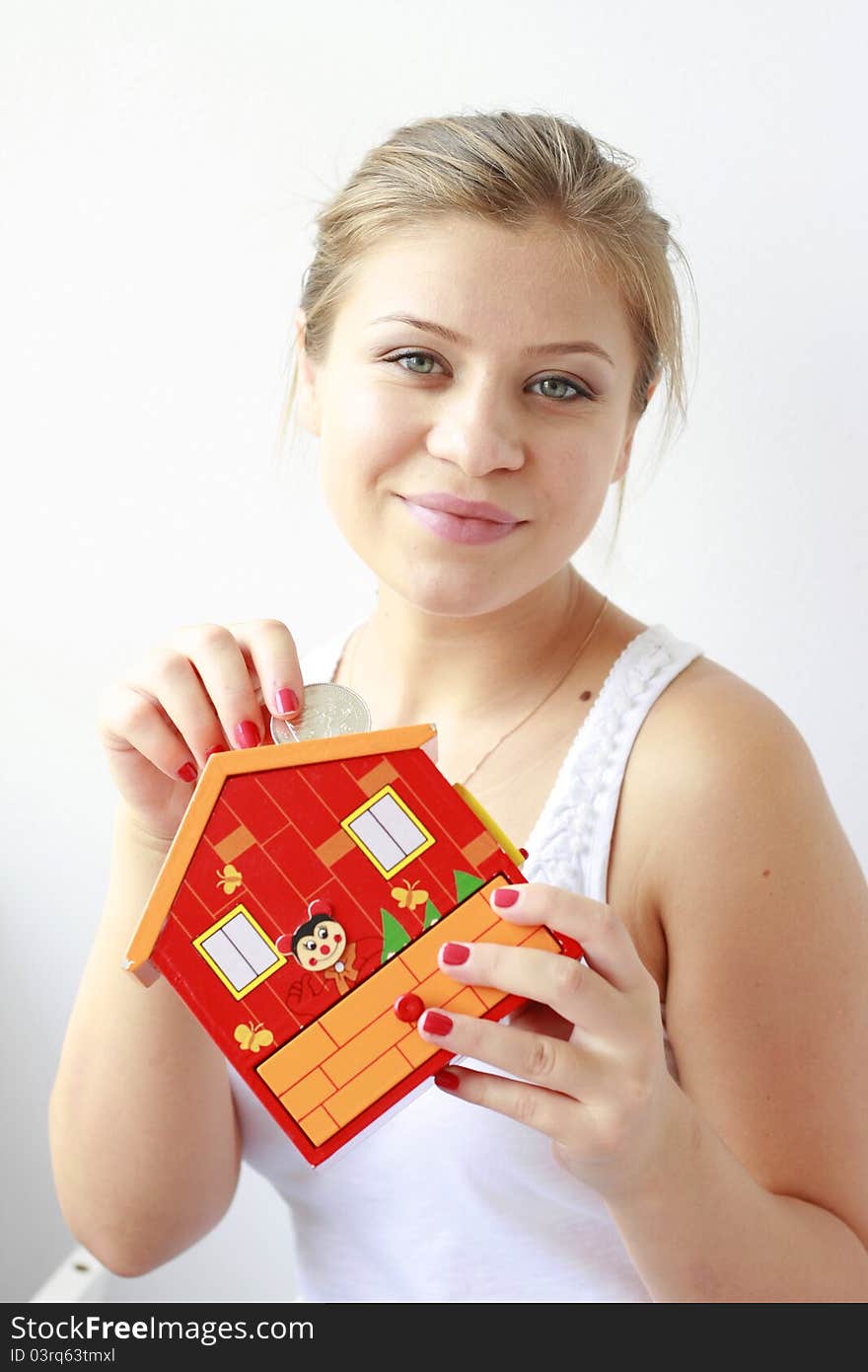 teenage girl putting coins in her moneybox