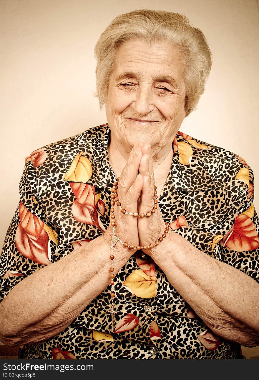 Elder woman in deep prayer.