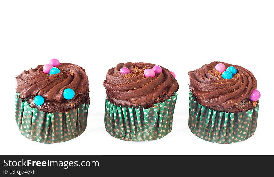 Miniature decorated chocolate cupcakes isolated on white background. Miniature decorated chocolate cupcakes isolated on white background