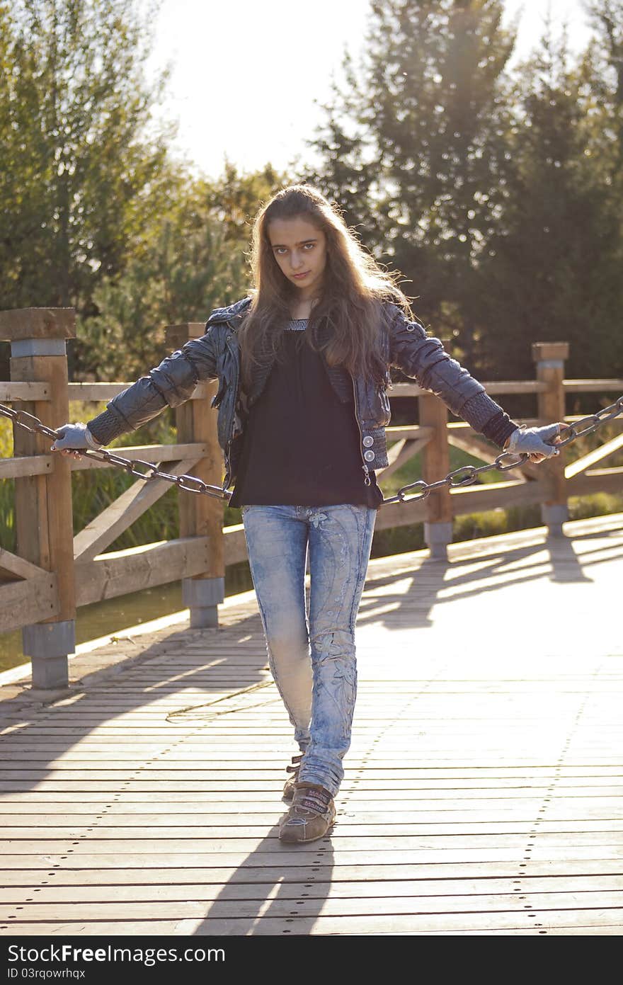 Teenage girl siting on the iron chain. Teenage girl siting on the iron chain