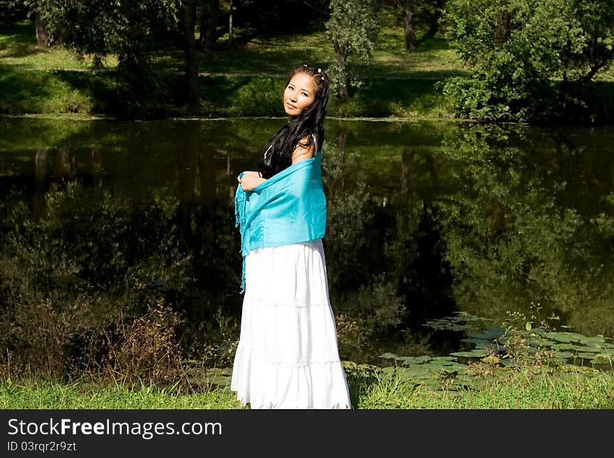 Beautiful pregnant girl walking in park in summer