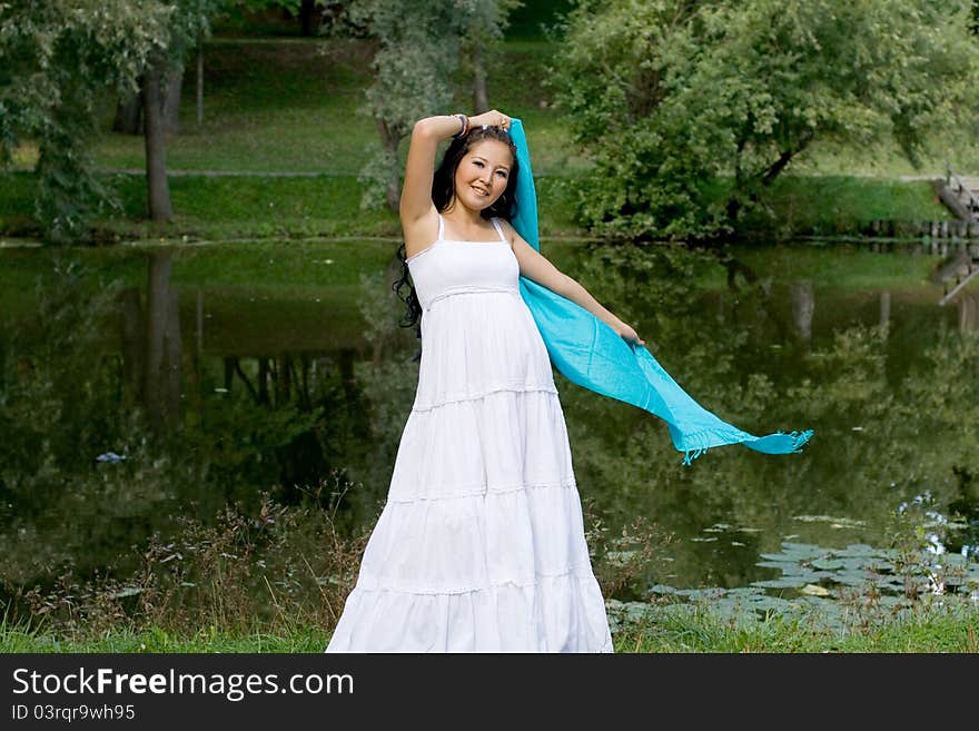 Beautiful pregnant girl standing near river in park. Beautiful pregnant girl standing near river in park