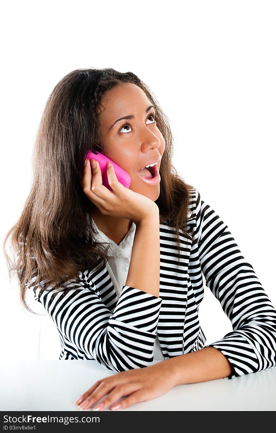 Teenage girl on pink phone listening at desk