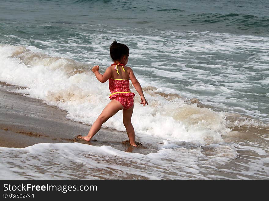 Little girl playing on the beach