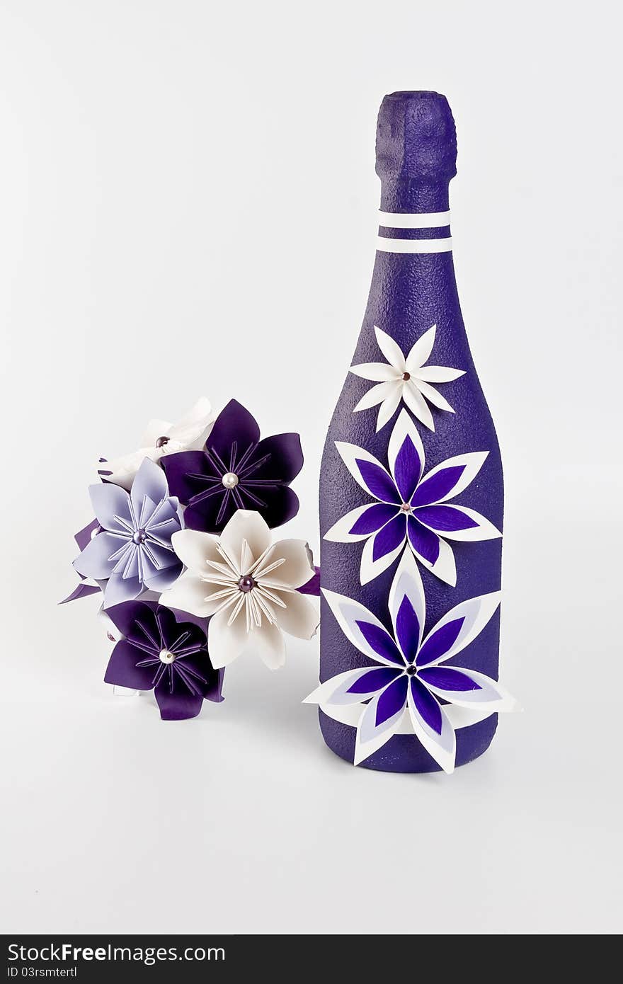 Bottle of champagne and origami artificial wedding paper bouquet - purple and white flowers with beads. Bottle of champagne and origami artificial wedding paper bouquet - purple and white flowers with beads