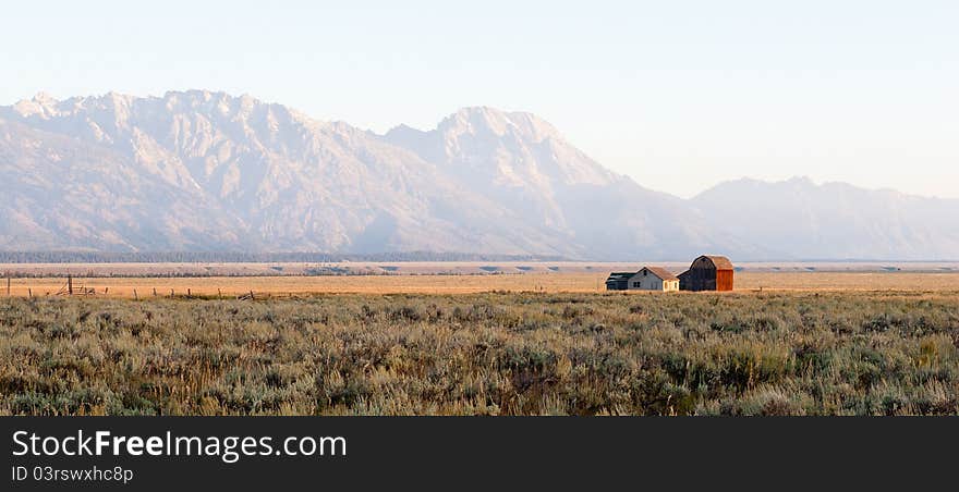 A lonely farm in front of the huge Grand Tetons mountain range. A lonely farm in front of the huge Grand Tetons mountain range