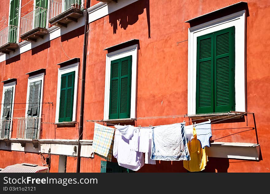 Detail of an ancient red house with a blue sky background in Procida Isle, Italy